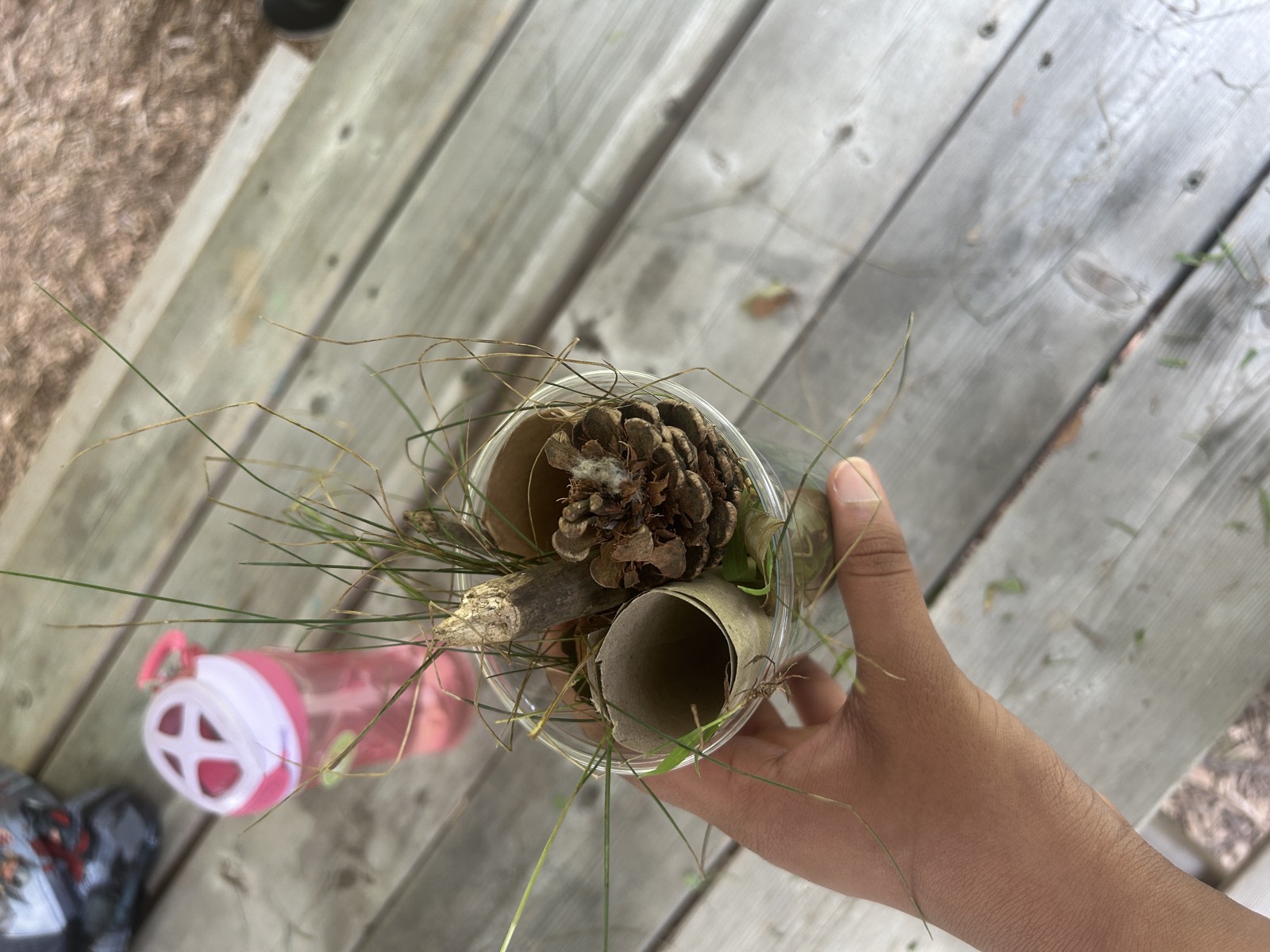 Elementary student holding a handmade bug hotel